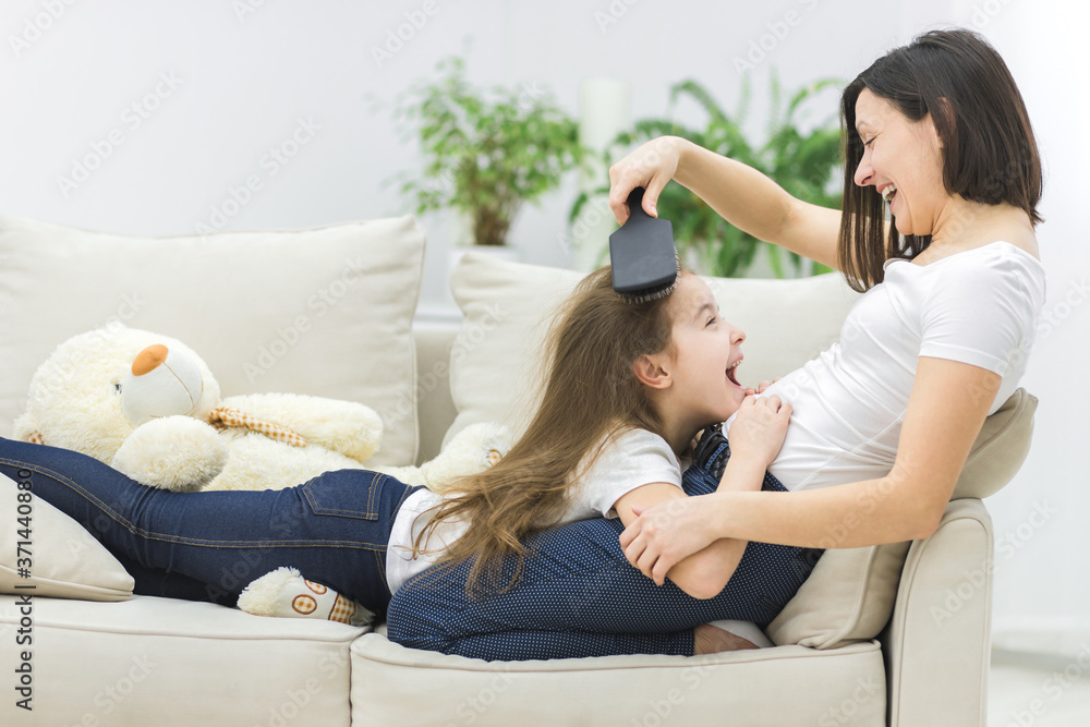 Photo of woman combing hair of her child. Photo of woman combing hair of her child.