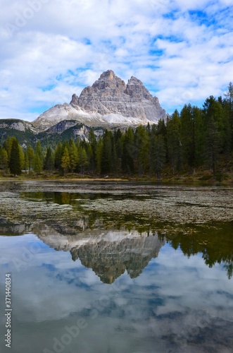 Tre Cime (Three Peaks) di Lavaredo Natural Park, Dolomites mountains, South Tirol, Italy, a lake in front, reflections on water surface, autumn landscape, blue sky with clouds background, a sunny day