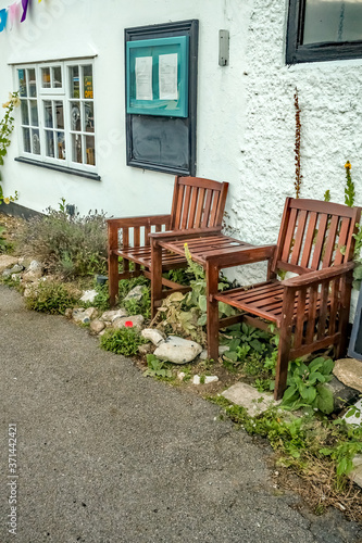 Wooden chairs and tables outside a pretty white building in the village of Horning in rural Norfolk