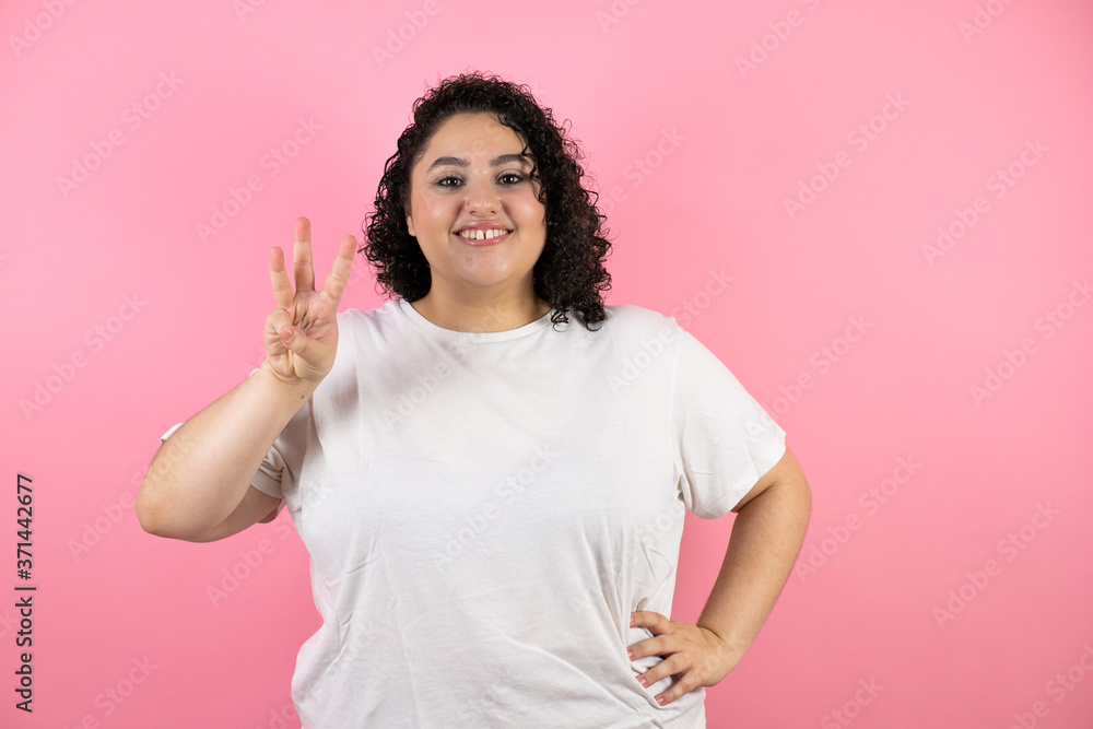 Fototapeta premium Beautiful young woman showing and pointing up with fingers number three while smiling confident and happy