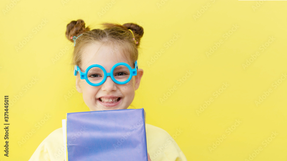 funny child girl yellow jacket on a yellow background, sitting, reading a book, development and school concept funny child girl yellow jacket on a yellow background, sitting, reading a book, development and school concept