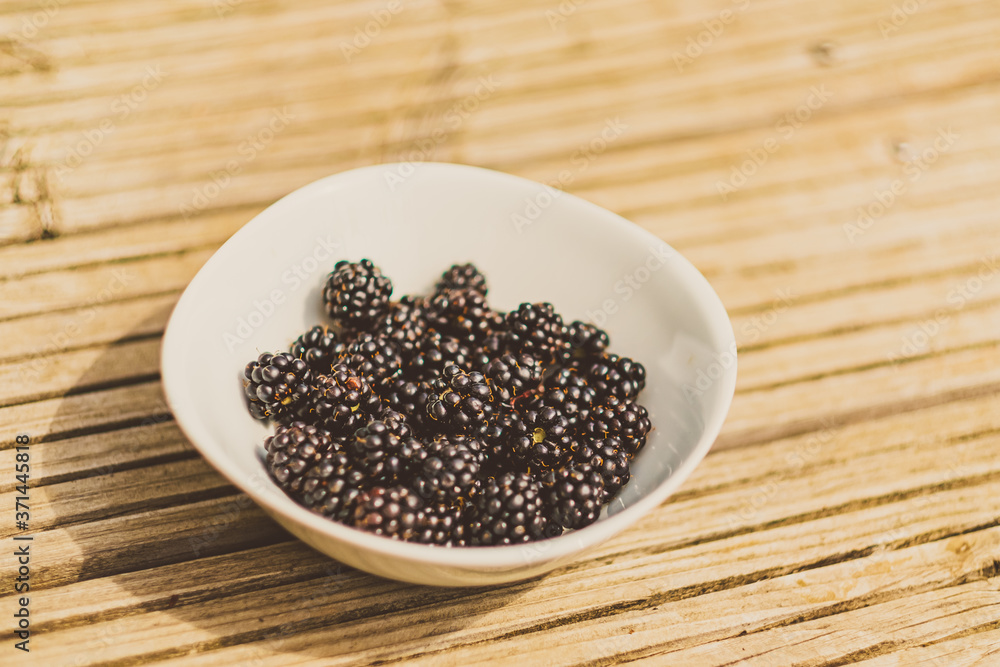 weiße Schale mit frischen Brombeeren auf Holz weiße Schale mit frischen Brombeeren auf Holz