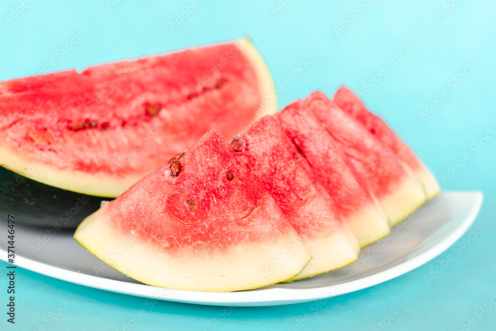 Water melon slices on a plate on blue background Water melon slices on a plate on blue background