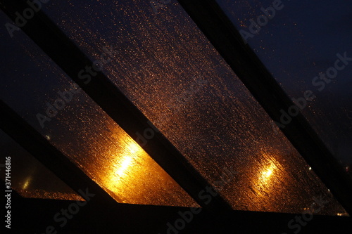 Pluies sur fenêtre avec éclairage la nuit. photo