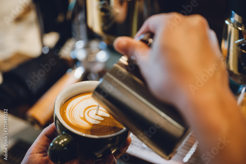 barista making latte art  shot focus in cup of milk and coffee  vintage filter image