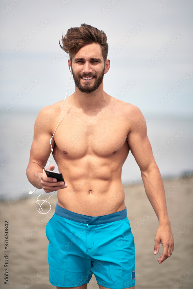 Attractive man walking on the beach; Hot guy concept