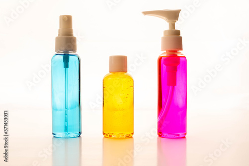 Colored alcohol sanitizers for pandemic time against white background. Disinfectant bottles against viral infections isolated on white background.