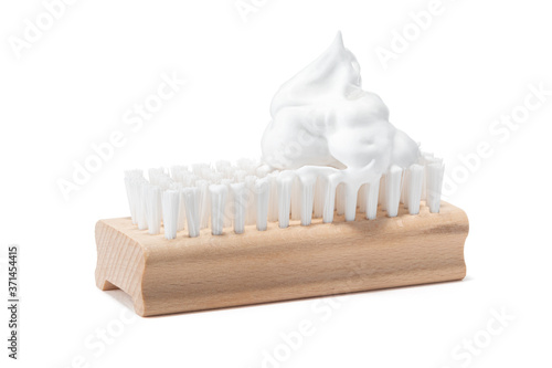 One wooden cleaning washing brush with synthetic nylon, polyester bristles and soap suds bubble or fluff frothed scouring foam on top. Isolated on white background. Cleaning service company concept. photo