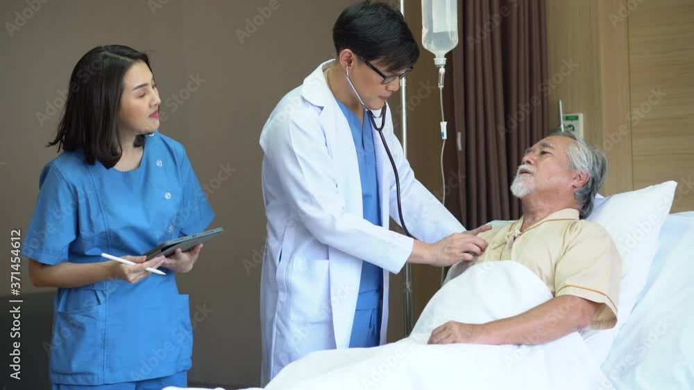 doctor examining senior old man patient with stethoscope Listening check heart lungs and nurse woman using digital tablet Talking With old man patient on bed in the hospital doctor examining senior old man patient with stethoscope Listening check heart lungs and nurse woman using digital tablet Talking With old man patient on bed in the hospital