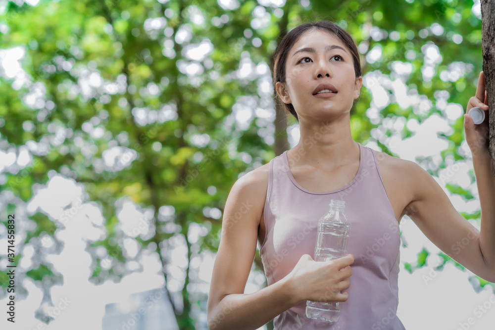 Young women drinking a water  after running and excercise.