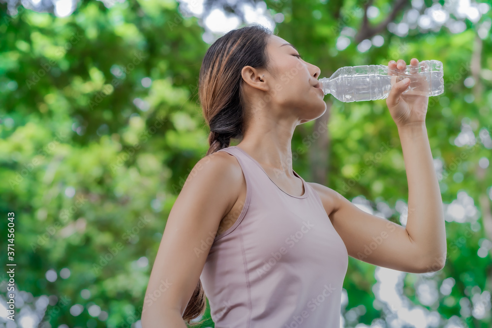 Young women drinking a water after running and excercise. Young women drinking a water after running and excercise.