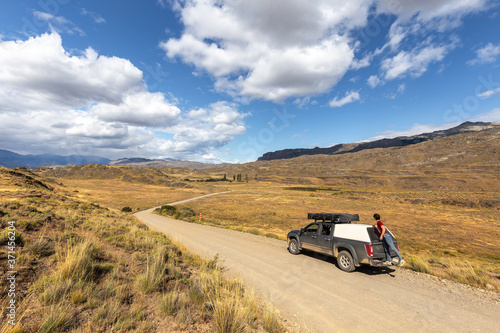 Driving on the road, tourists cross the chacabuco valley national park in solitude aboard a car equipped with a tent.