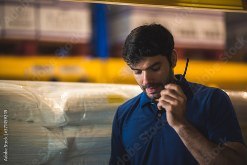 Male warehouse worker working for check and analyze newly arrived goods for further placement in storage department. Employee organizing goods distribution to the market