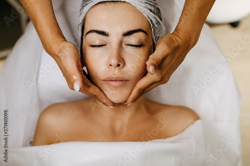 Young woman at a beauty salon having a face massage. Face lifting procedures.