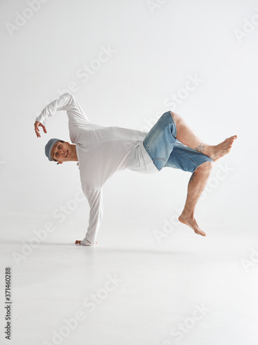 Fototapeta Naklejka Na Ścianę i Meble -  Cool guy breakdancer dancing lower break dance isolated on white background. Break dance lessons