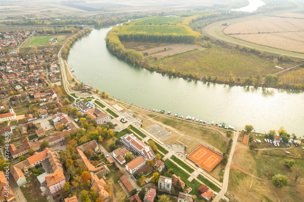 Aerial dramatic view of serbian town Novi-Becej red roof buildings and riverside.