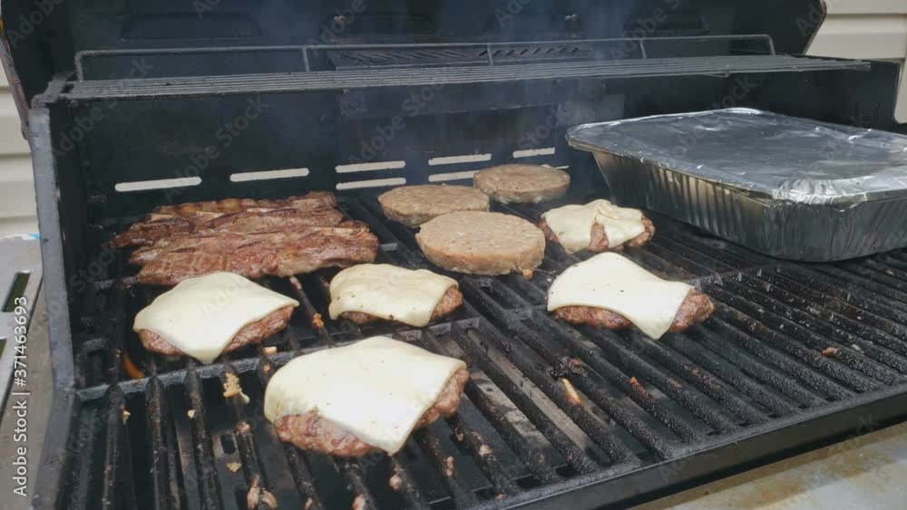 Home cooking Cooking on gas grill food like beef burgers with slices