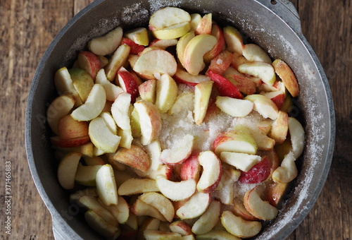 Cook homemade jam. Apple slices in a saucepan, covered with sugar, are ready to make the jam.