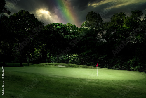 Rainbow arching over hole and flag on a golf course