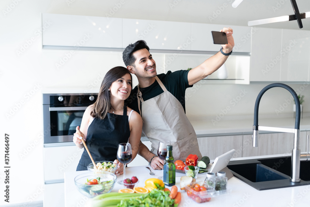 Hispanic Couple Enjoying Cooking Together In Kitchen