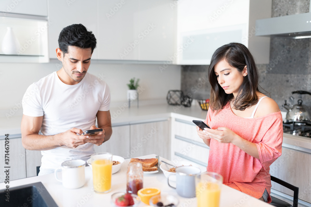 Couple Busy With Mobile Phones During Breakfast Couple Busy With Mobile Phones During Breakfast
