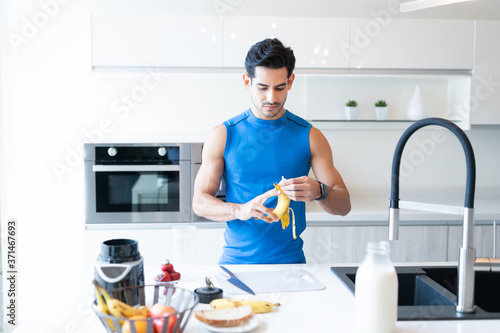 Hispanic Man Eating Banana At Home