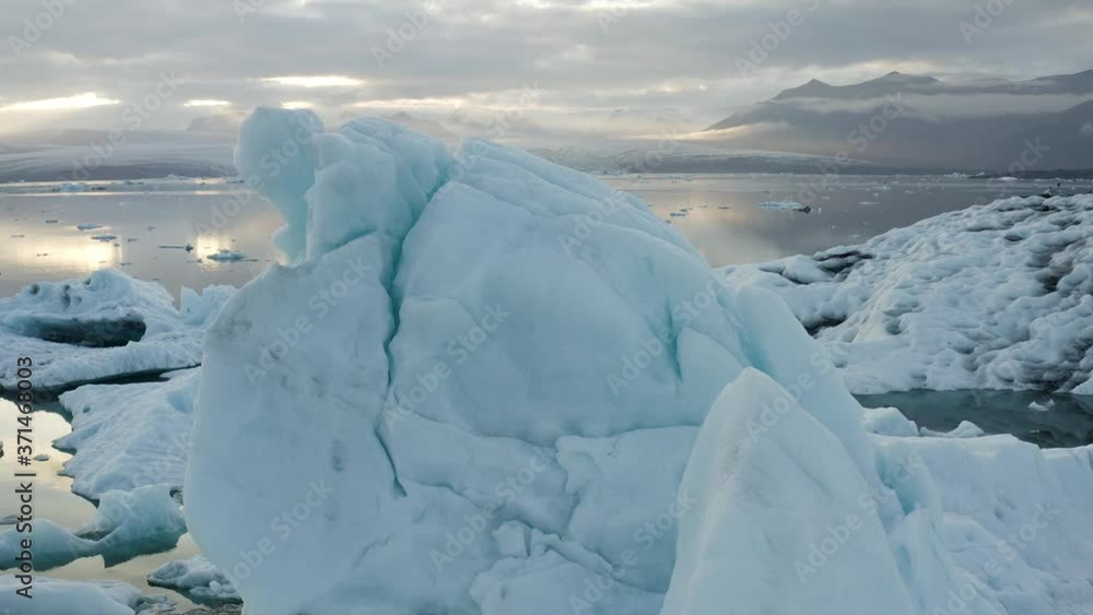 Aerial: Flight over floating Icebergs In Glacial lagoon lake Sunset Evening colors Iceland Concept of Global warming Aerial: Flight over floating Icebergs In Glacial lagoon lake Sunset Evening colors Iceland Concept of Global warming