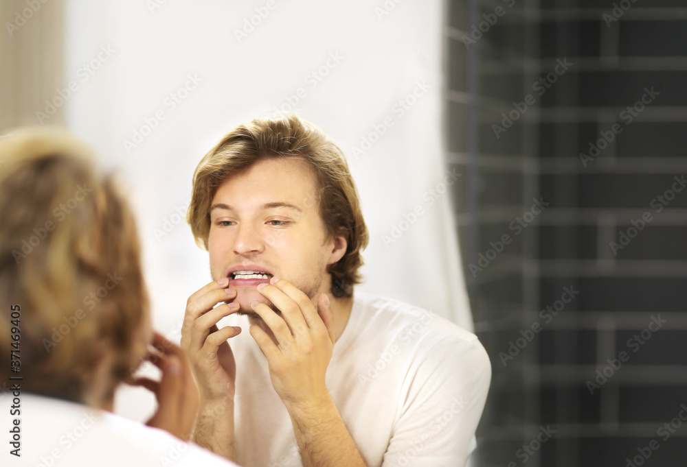 Applying the cream.young man looking in the mirror Applying the cream.young man looking in the mirror