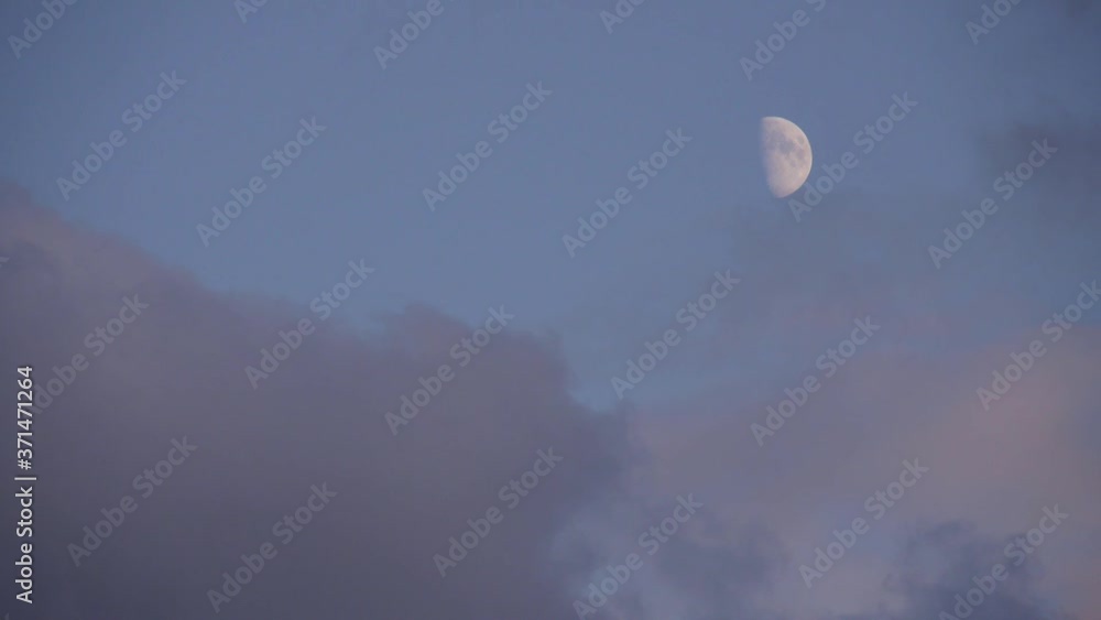 Abnehmender Halbmond am Abendhimmel zur blauen Stunde mit vorbeiziehenden Wolken Abnehmender Halbmond am Abendhimmel zur blauen Stunde mit vorbeiziehenden Wolken