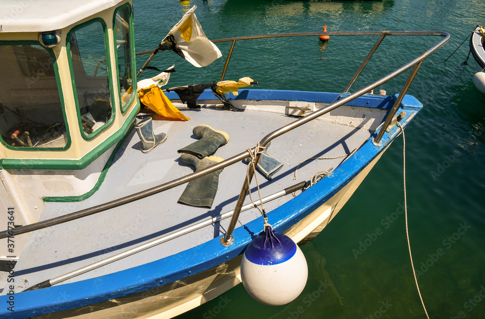 High-angle view of the bow of a fishing boat with rubber boots and fishing gear, Liguria, Italy