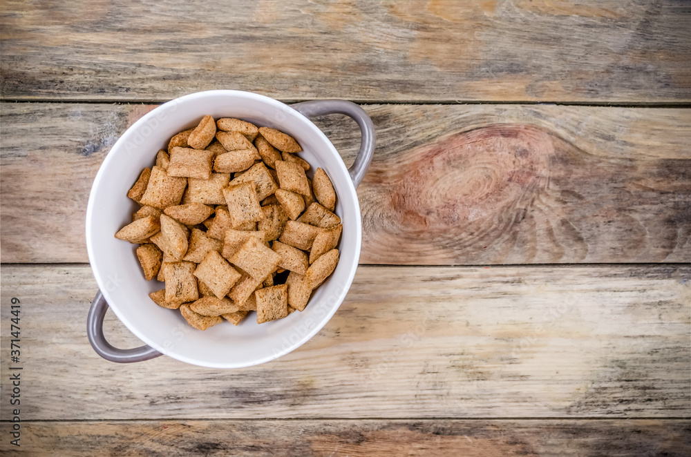 Bowl with sweet corn pads with chocolate inside on a wooden background, copy space, top view Bowl with sweet corn pads with chocolate inside on a wooden background, copy space, top view