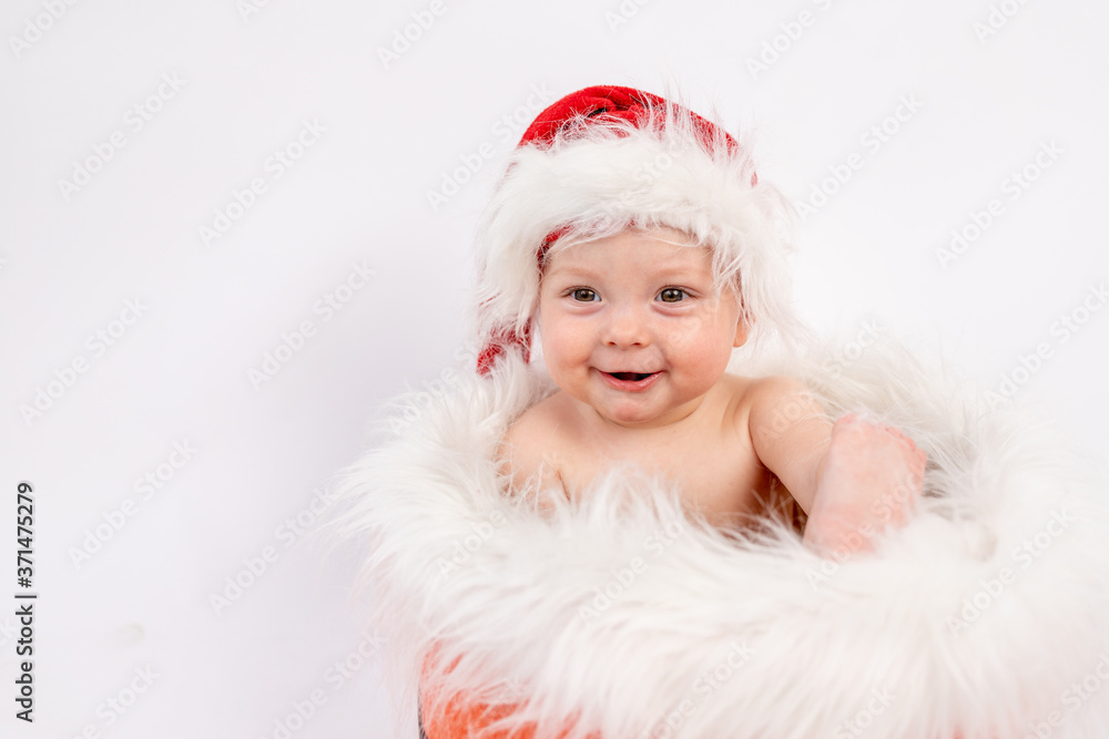 portrait of a small child girl sitting in a Santa hat in a basket on a white isolated background, happy new year 2021, space for text portrait of a small child girl sitting in a Santa hat in a basket on a white isolated background, happy new year 2021, space for text