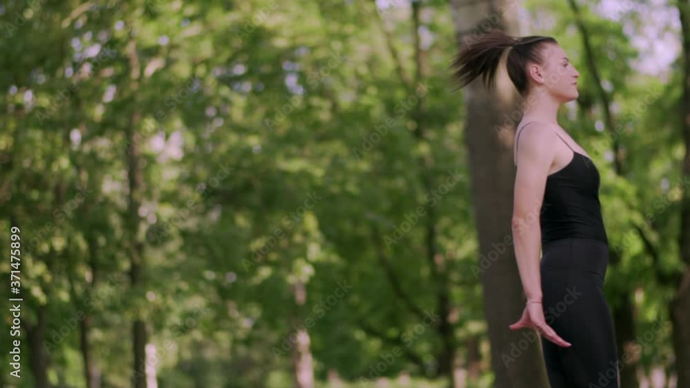 Young woman gymnast jumping in twine on in the park, slow motion. Young woman gymnast jumping in twine on in the park, slow motion.