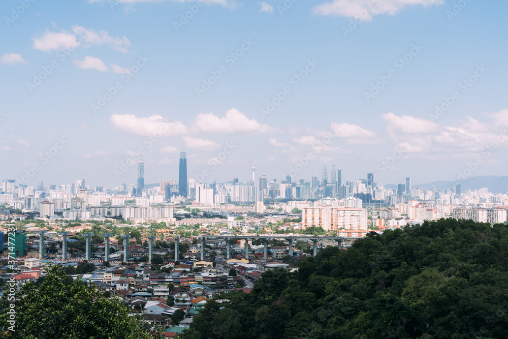 View from a hill with trees of a city with the skyscrapers in the background
