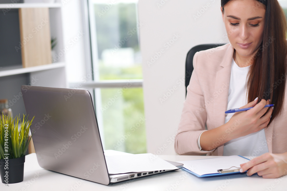 Young female content manager makes notes with a pen Young female content manager makes notes with a pen