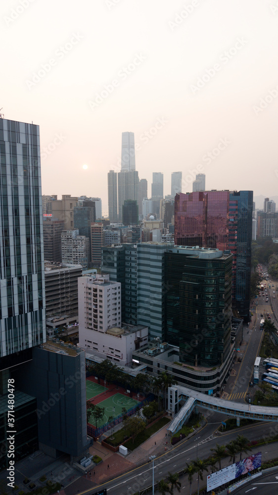Obraz premium Hong Kong / March 28 2018: Aerial view of Hong Kong cityscape. Skyscrapers high glass buildings business centers roads car traffic daily city life. Concrete jungle. Megalopolis. Smog gray cloudy sky