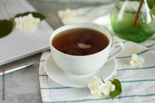 a Cup of tea and Jasmine flowers on the table on a spring morning