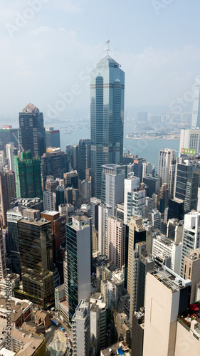 Hong Kong   March 28 2018  Aerial view of Hong Kong city. Skyscrapers  office glass buildings business centers near Victoria harbour bay concrete jungle megalopolis cityscape city life. Sunny blue sky