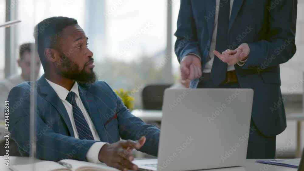 African businessman discuss project planning with colleague at modern workplace African businessman discuss project planning with colleague at modern workplace