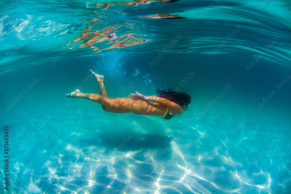 A young woman swim underwater at Campeche Island in Florianopolis Brazil
