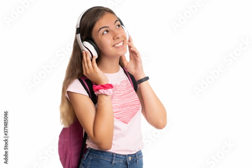 Girl with backpack smiling and listening to music on white background