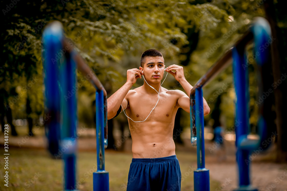 Obraz premium Sportsman with earphones training in the park