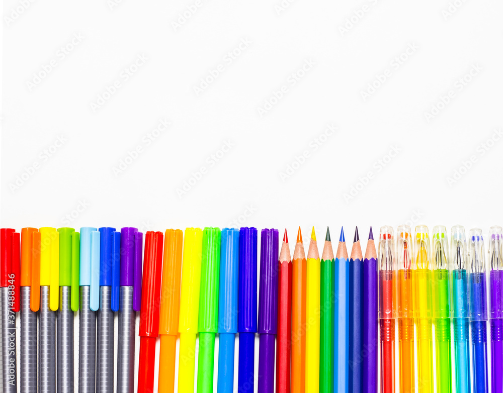 Back to school. School supplies pens, pencils, markers are laid out in the form of a rainbow. Space for text. The view from the top Back to school. School supplies pens, pencils, markers are laid out in the form of a rainbow. Space for text. The view from the top