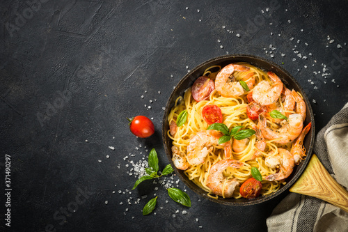 Pasta seafood with shrimp on black table.