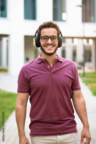 Portrait of handsome man smilling with eyeglasses and headphones.