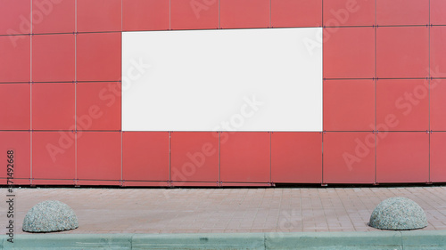 big empty banner with white mock-up on red wall over sidewalk