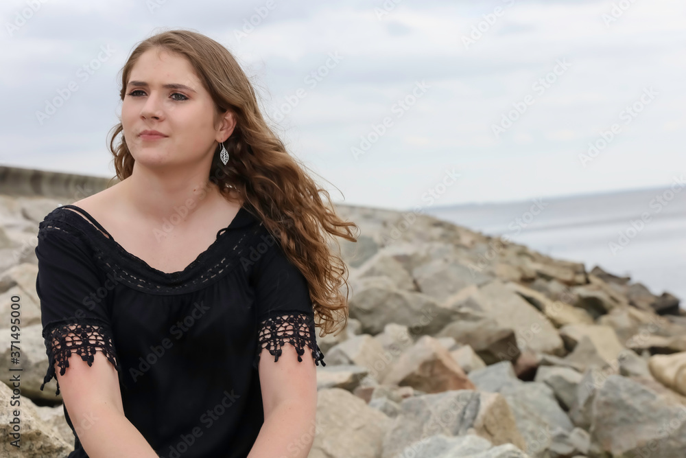 Young Model Sitting On Rocks