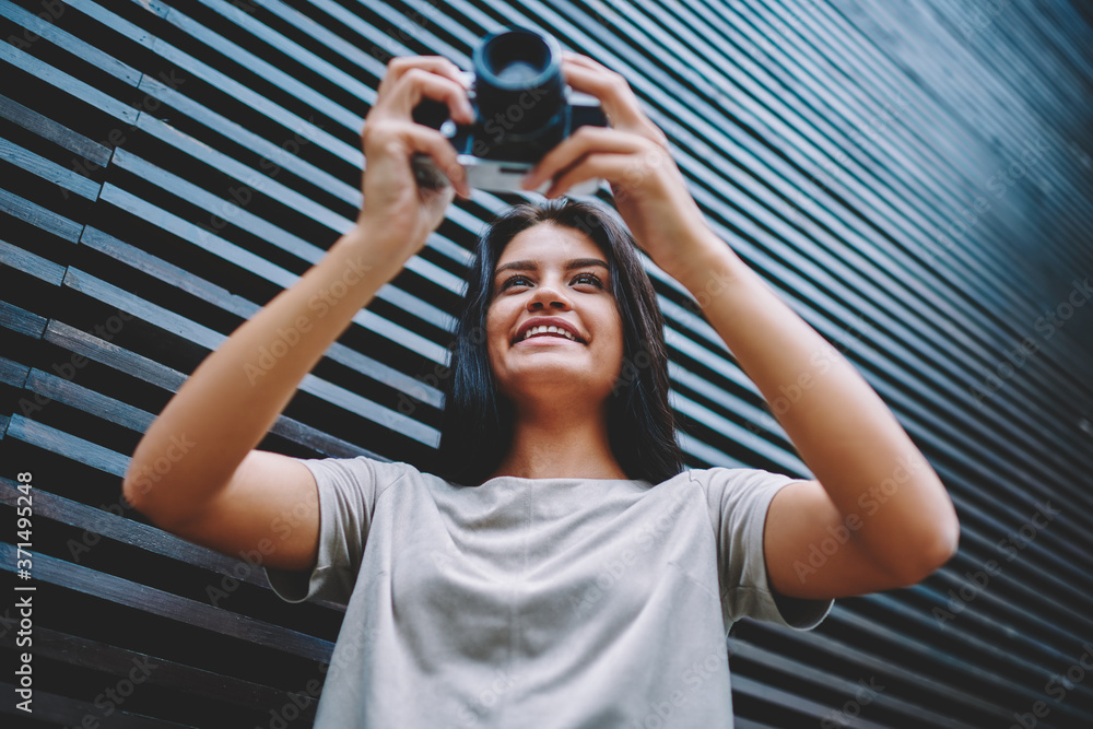 Happy smiling female amatour photographer 20 years old checking photos