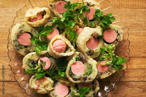 Delicious pieces of baked sausages with herbs laid