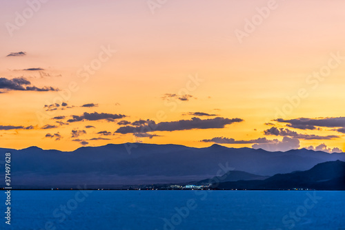 Bonneville Salt Flats colorful orange blue dark twilight silhouette mountain view with highway lights after sunset near Salt Lake City  Utah with clouds